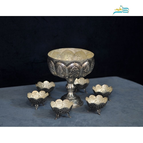 نمای نزدیک نقش‌ها و جزئیات اجرای قلم‌زنی اعلاء روی بدنه برنجی.