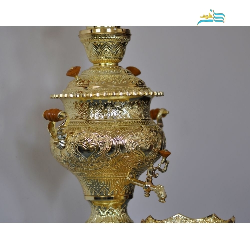نمای نزدیک جزئیات ظریف قلم‌زنی اعلاء روی بدنه برنجی سماور.