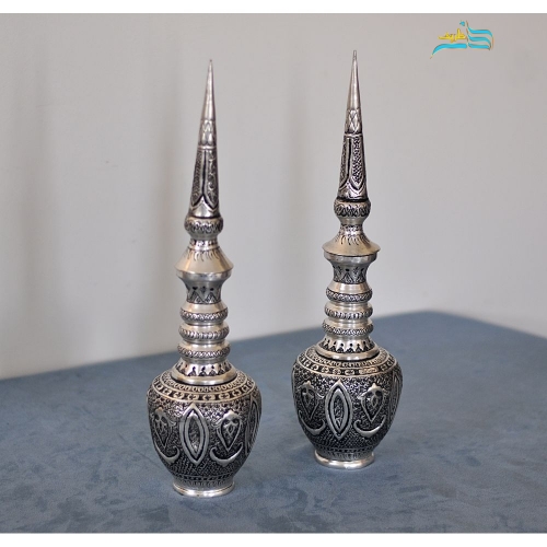 نمای نزدیک از جزئیات قلم‌زنی دست، روکش نقره و طرح سیاه قلم.