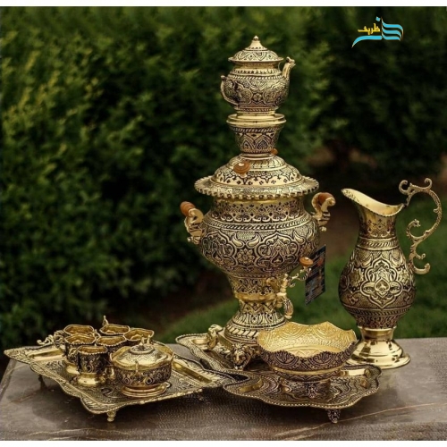 نمای کامل از سرویس سماور چهار لیتری با روکش طلا و سیاه قلم، شامل سماور، پارچ، جام، سینی، قوری، گیره‌ها، قندان و سینی چایخوری.