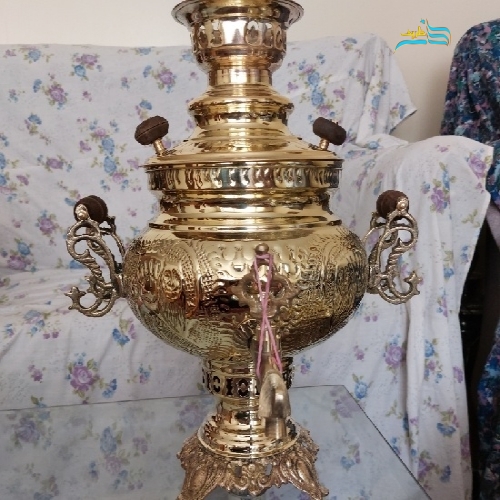 نمای کامل از سماور برنجی با دسته ماهی و بدنه ضخیم، نمایش فرم، ظرفیت ۶ لیتری و زیبایی کلی.